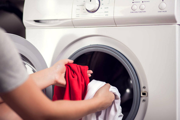 Chargement des vêtements blancs et de couleur dans la machine à laver. Laver les vêtements en différentes couleurs - Photo, image