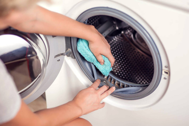 Piszkos penészes mosógép tömítő gumi és dob közelről. Penész, kosz, mészkő a mosógépben. Háztartási készülékek időszakos karbantartása. - Fotó, kép