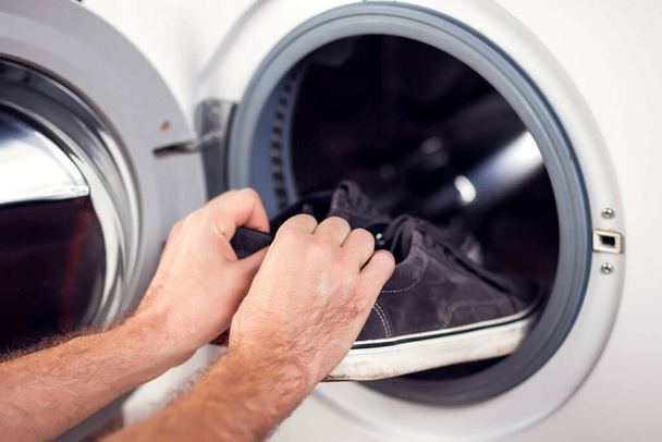 Chargement des gaines dans la machine à laver. Travaux ménagers, concept de blanchisserie - Photo, image
