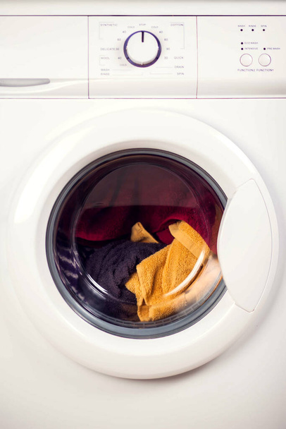 Λευκό πλυντήριο γεμάτο ρούχα, κλείστε το. Πλυντήριο ρούχων και έννοια - Φωτογραφία, εικόνα