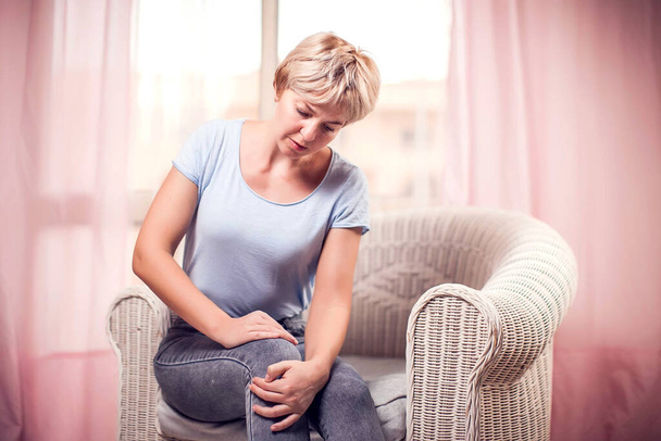 Woman feels knee pain. People, healthcare and medicine concept - Foto, imagen