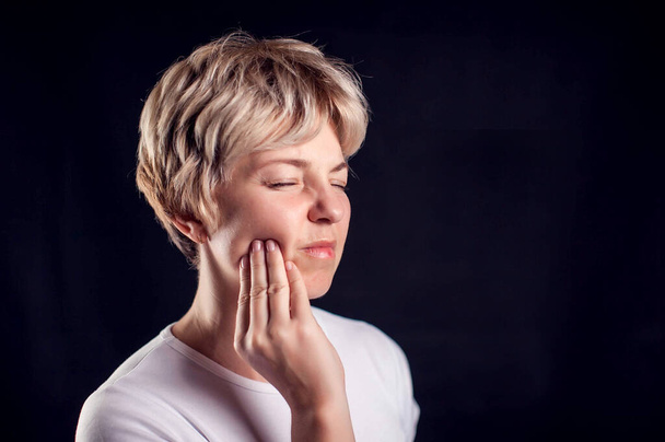 Vrouw voelt tandpijn. Begrip "mens, gezondheidszorg en geneeskunde" - Foto, afbeelding