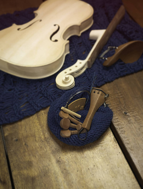 Частини скрипки наносять на дерев'яну дерев'яну дошку, розмивають світло навколо
 - Фото, зображення