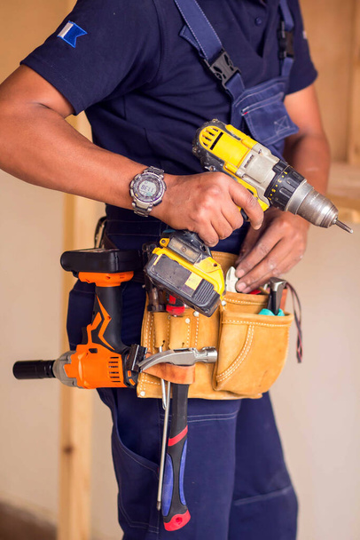 Handyman con cuffie gialle funziona con trapano fa riparazione. - Foto, immagini