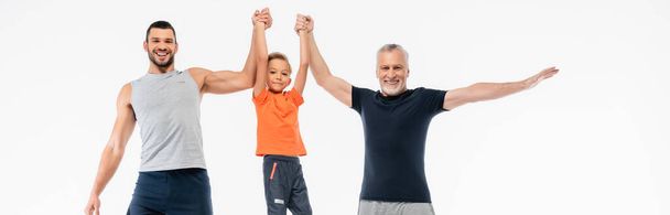 happy grandfather and dad raising kid and smiling at camera isolated on white, banner - Foto, imagen