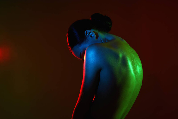 Kobiece plecy. Naga kobieta w kolorowych jasnych światłach. piękne nagie ciało sylwetka dziewczyna - Zdjęcie, obraz
