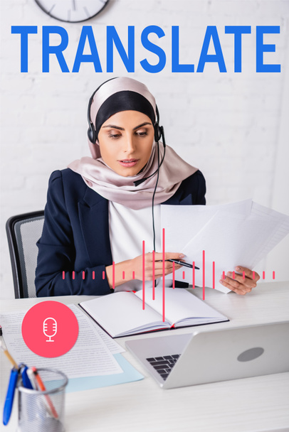 arabski tłumacz w słuchawkach pracujących z dokumentami w pobliżu notebooka i laptopa, przetłumaczyć liternictwo w pobliżu mikrofonu i skali głośności ilustracji - Zdjęcie, obraz