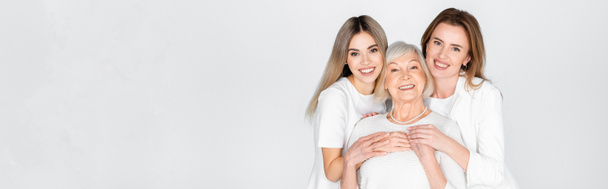 three generation of happy women smiling while looking at camera isolated on grey, banner - Foto, Imagem