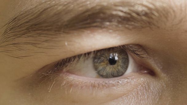 Nahaufnahme des menschlichen Auges, das die Konzentration auf das Objekt ausdrückt. Handeln. Männliche Augen im Sonnenlicht schauen geradeaus und starren. - Foto, Bild