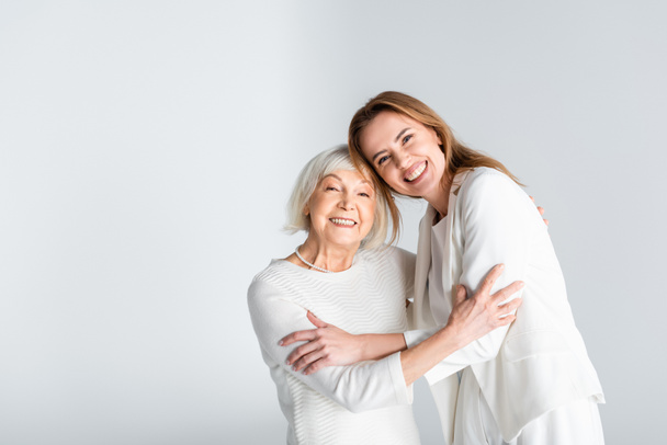 senior mother hugging with happy daughter isolated on grey  - Foto, Bild