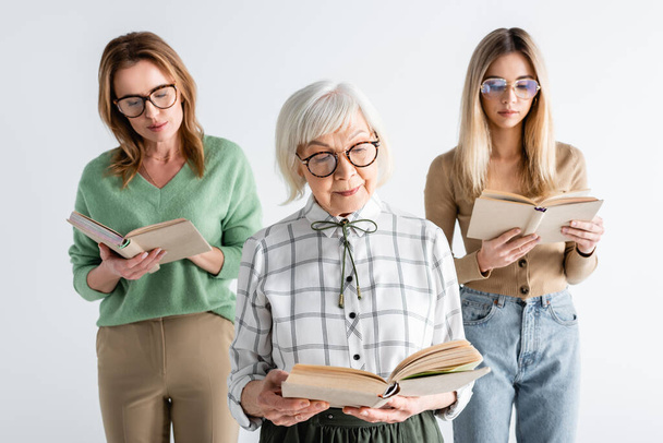 three generation of women in glasses reading books isolated on white - Φωτογραφία, εικόνα
