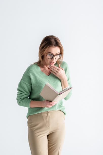 surprised woman in glasses reading book isolated on white - Fotografie, Obrázek