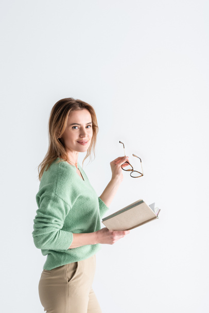 cheerful woman holding glasses and book isolated on white - Fotografie, Obrázek