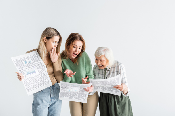 tres generaciones de mujeres sorprendidas leyendo periódicos aislados en blanco - Foto, Imagen