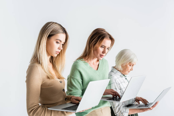 three generation of women using laptops isolated on white - Foto, afbeelding