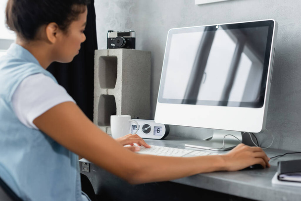 jovem freelancer afro-americano trabalhando no laptop em casa, foreground borrado - Foto, Imagem