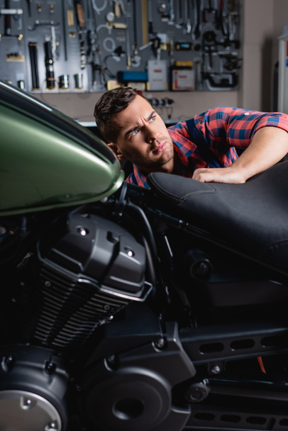 nuori mekaanikko tekee diagnostiikka moottoripyörä autotallissa - Valokuva, kuva