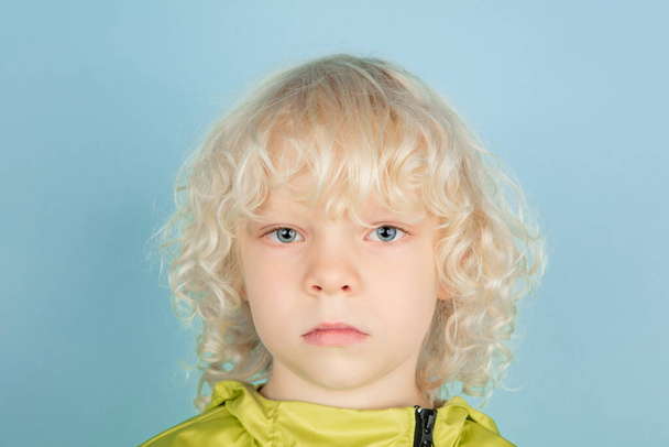 Portrait of beautiful caucasian little boy isolated on blue studio background - Photo, Image