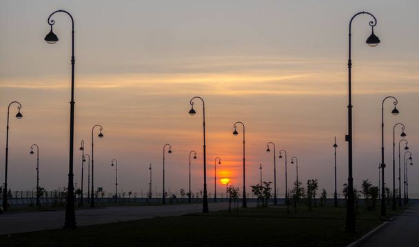 lampioni elettrici sullo sfondo del sole al tramonto. - Foto, immagini