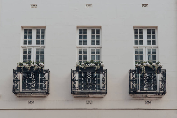Vue en angle bas des balcons avec pots de fleurs d'un immeuble d'appartements blanc traditionnel à Mayfair, Londres, Royaume-Uni. - Photo, image