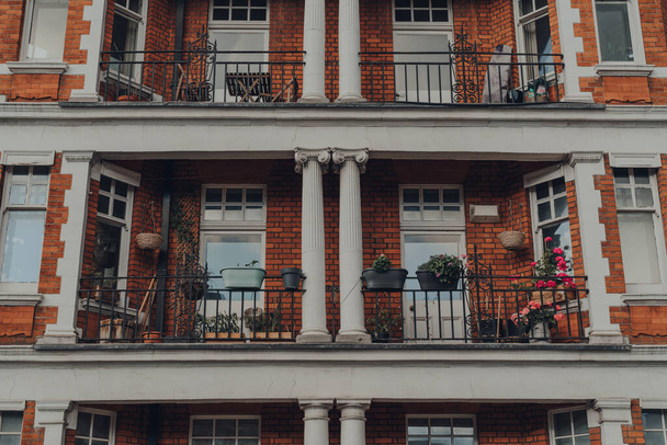 Vue en angle bas des balcons d'un immeuble d'appartements traditionnel en brique rouge à Mayfair, Londres, Royaume-Uni. - Photo, image