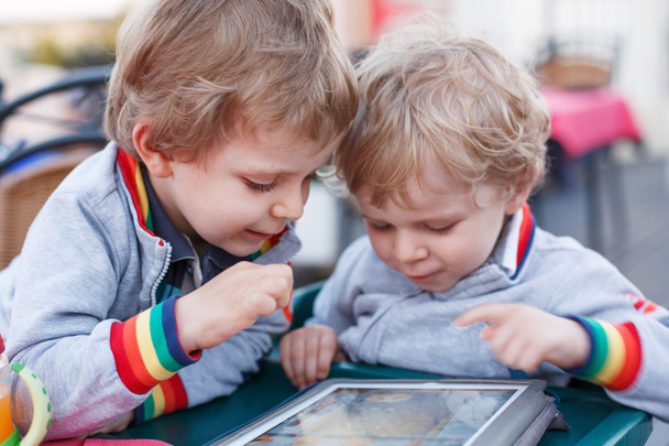 tablet pc ile birlikte eğlenmek iki küçük kardeş çocukları. - Fotoğraf, Görsel
