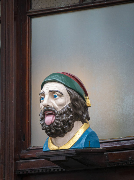 Büste eines bärtigen Mannes, der seine Zunge herausstreckt in der Stadt Gouda, Niederlande - Foto, Bild