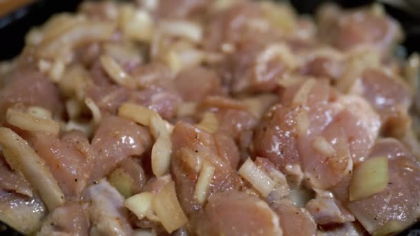 Cozinhar carne crua de frango em uma frigideira no fogão a gás na cozinha em casa - Filmagem, Vídeo