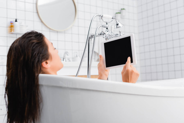 young woman taking bath and using digital tablet - Фото, изображение