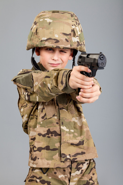 Young boy dressed like a soldier with a gun - Fotó, kép