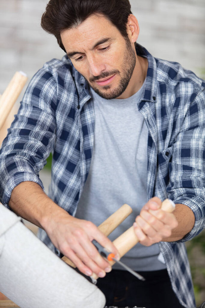 young man repairing furniture at home - Фото, зображення