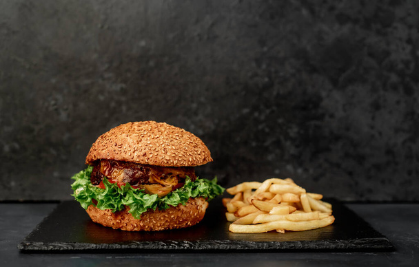 Panino fresco con carne, primo piano di hamburger fritto su sfondo di pietra nera - Foto, immagini