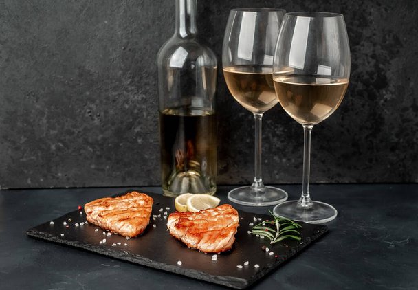 Composition with fresh salmon and wine on black stone background - 写真・画像