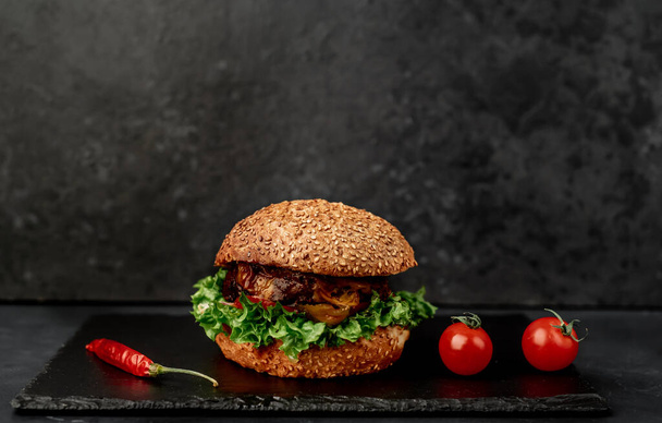 Fresh sandwich with meat, closeup of fried burger on black stone background - Photo, Image