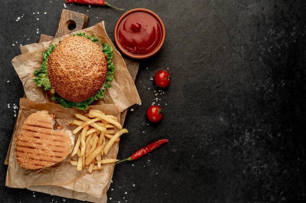 Sandwich frais à la viande, gros plan de hamburger frit sur fond de pierre noire - Photo, image