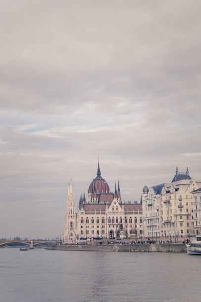 A vertical shot of the Hungarian Parliament Building along the Danube River in Hungary - Foto, Imagen