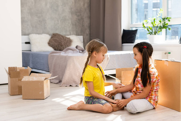 Excited funny kids girls running inside luxury big modern house on moving day, cute children entering exploring new home, happy young family buying real estate - Photo, Image