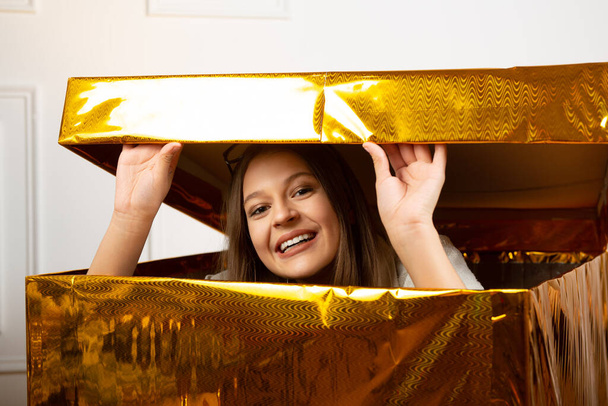 beautiful young female peeking out of the holiday box - Foto, Imagen