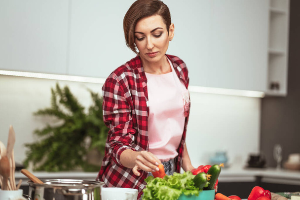 Cooking at home for loving family. Preparing ingredients on table young woman cooking a lunch standing in the kitchen. Healthy food living. Healthy lifestyle - Foto, Bild