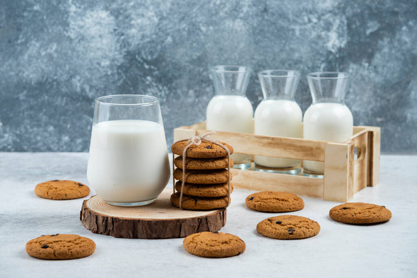 Uma xícara de leite com biscoito de chocolate em uma placa de madeira - Foto, Imagem