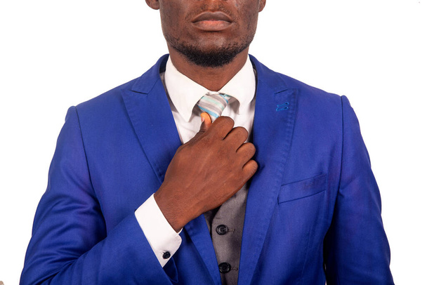 um atraente jovem empresário de pé isolado no fundo branco ajustando sua gravata - Foto, Imagem