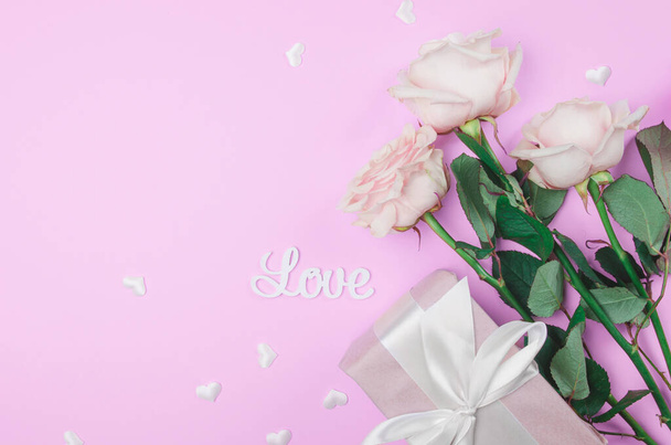 Valentines day background with flowers and a gift. Flat lay, copy space. - Photo, Image