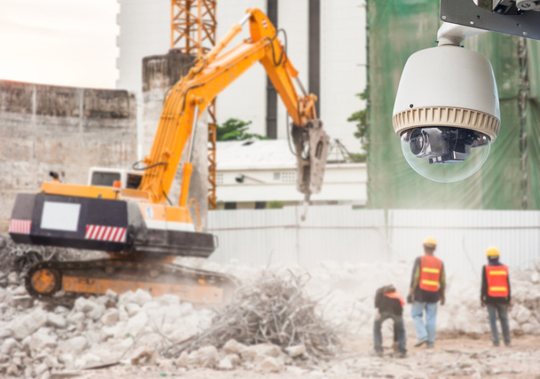 CCTV camera kijken naar een graafmachine en werknemers werken op een bouwplaats - Foto, afbeelding