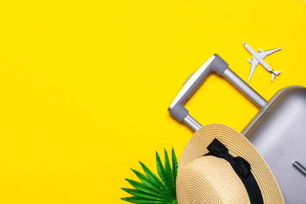 夏のパターンの背景。スーツケース、ヤシの葉とわらの帽子を持つサングラス、黄色の背景に旅行組成の白い飛行機。トップビュー、フラットレイアウト。スペースのコピー - 写真・画像