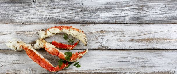 King crab claws and legs on white rustic wood in flat lay format  - Foto, imagen