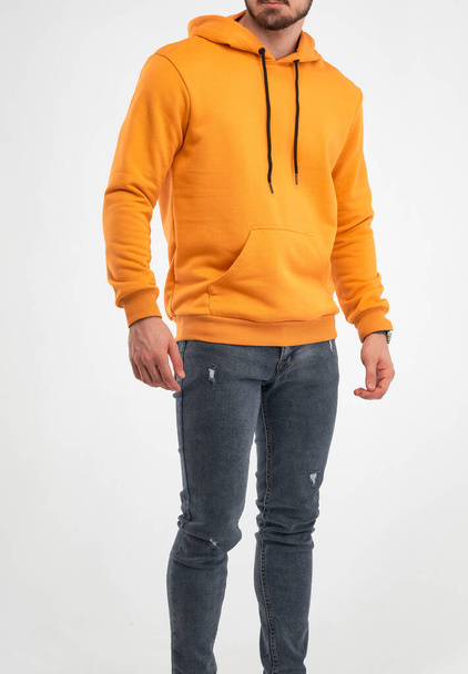 Narancssárga kapucnis férfi. A fickó utcai ruhákat visel. elszigetelt stúdió fotó férfiak ruházat - Fotó, kép
