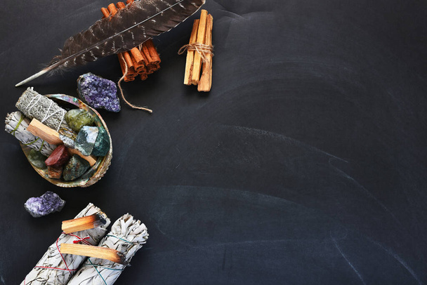 A top view image of several items of a sacred smudge kit on a black background.   - Photo, Image