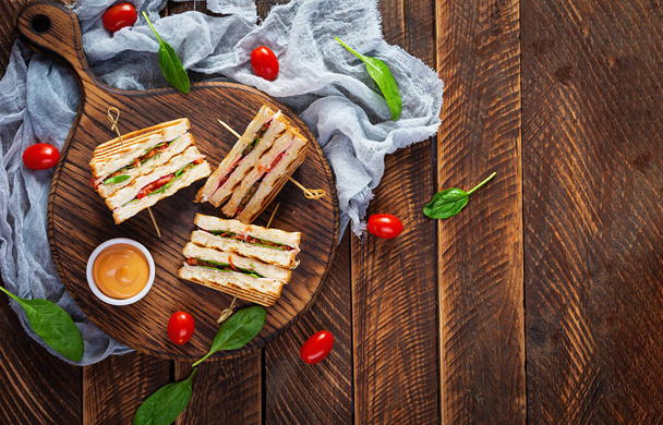 Clubsandwich met ham, tomaat, kaas en spinazie. Gegrilde panini. Bovenaanzicht - Foto, afbeelding