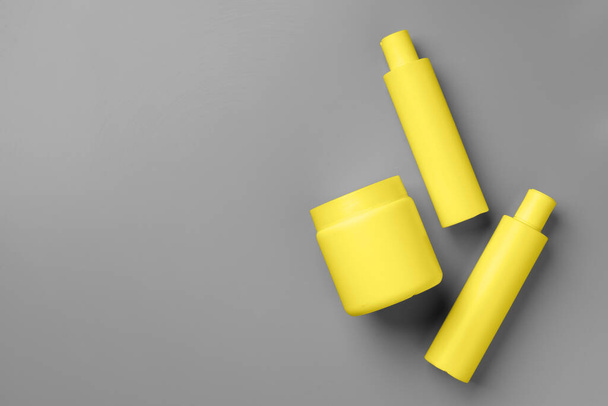 Yellow cosmetic container on gray background top view - Foto, imagen