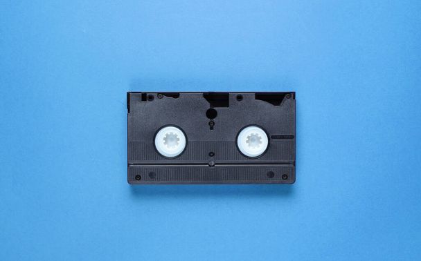 Cultura pop atributos retro 80, cassete de vídeo em fundo azul. Vista superior - Foto, Imagem